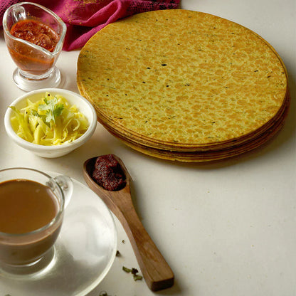 Close-up of a crispy round Indian snack, emphasizing its thinness.